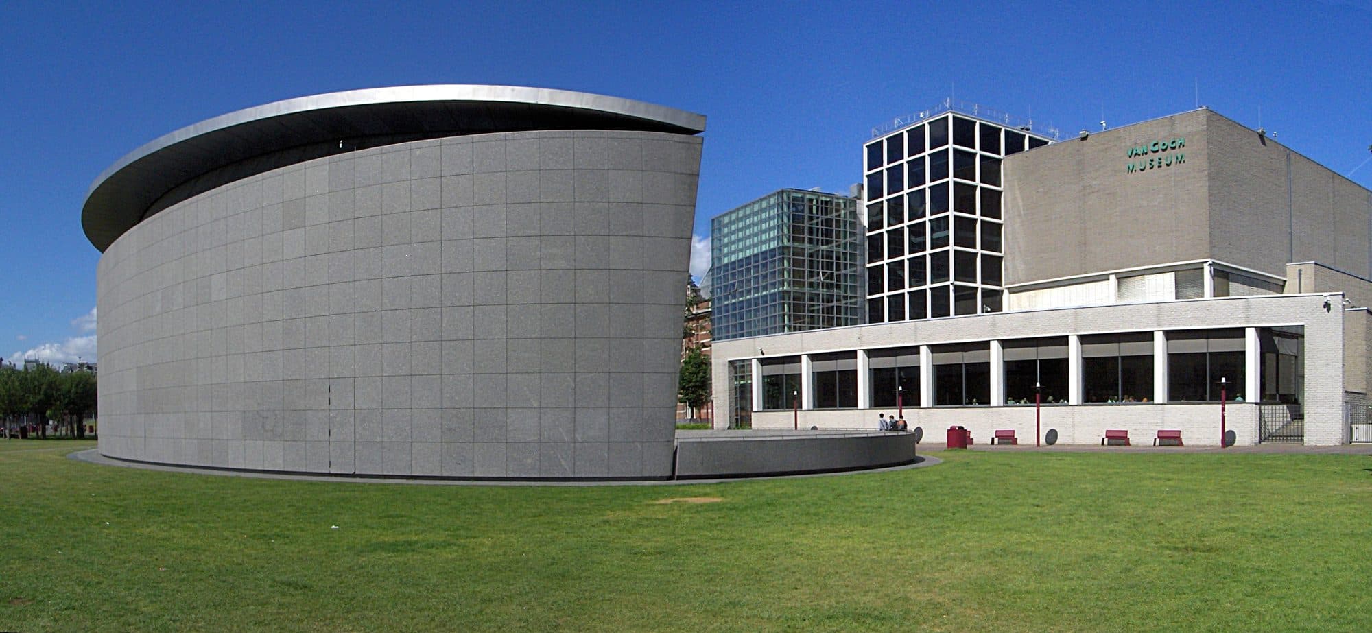 The Van Gogh Museum seen from the Museumplein, a low glass and stone building with the lawn in front